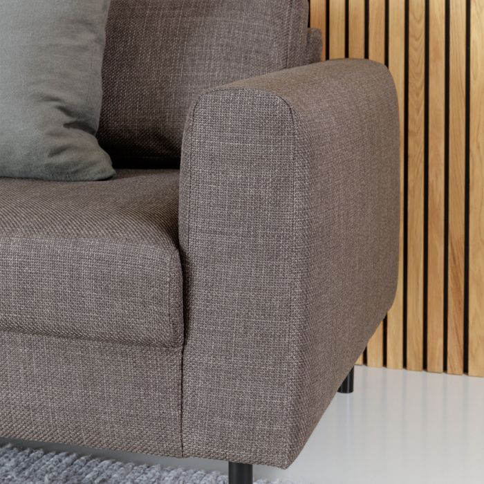 Gray upholstered chair with wooden slat wall in the background