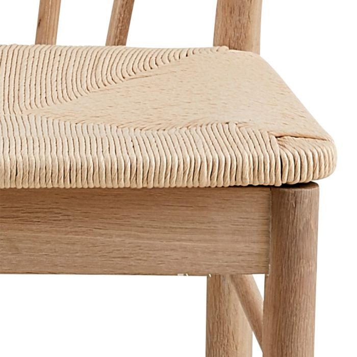Close-up of a wooden chair with a woven seat on a white background