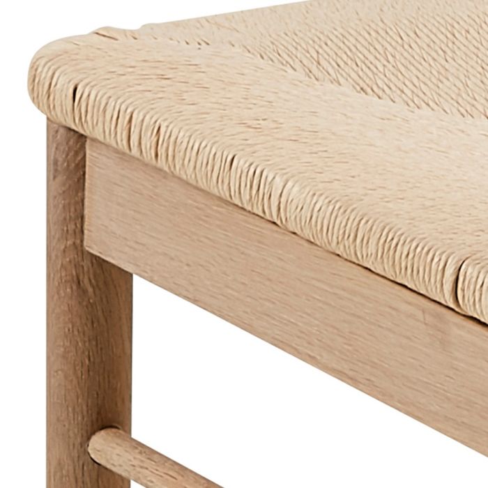 Close-up of a wooden bench with a beige cushion on a white background