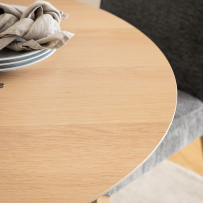 Round wooden table with a gray base and a cloth on top