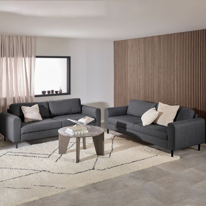 Modern living room with two gray sofas, a coffee table, and decorative pillows.