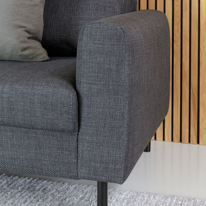 Gray upholstered chair with wooden slat wall in the background