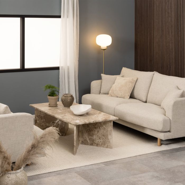 Modern living room with a beige sofa, marble coffee table, and decorative elements.