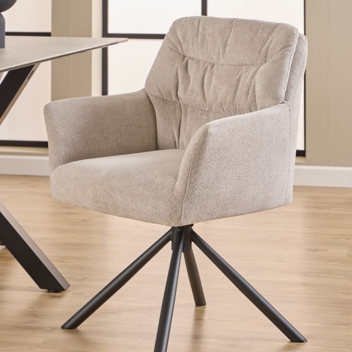 Beige armchair with black metal legs on a wooden floor