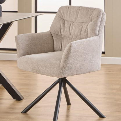 Beige armchair with black metal legs on a wooden floor