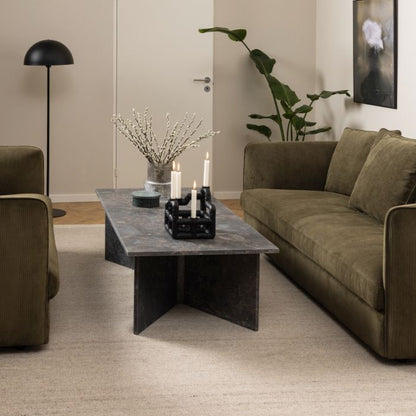 Modern living room with a gray coffee table, brown sofa, and decorative elements.