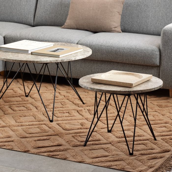 Two marble coffee tables with black metal legs in a living room setting.