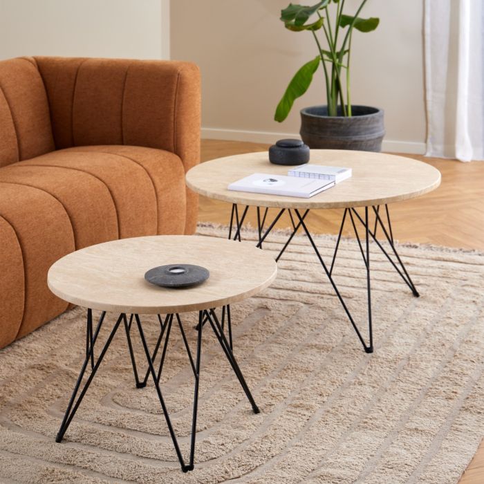 Two round coffee tables with black metal legs in a living room setting.