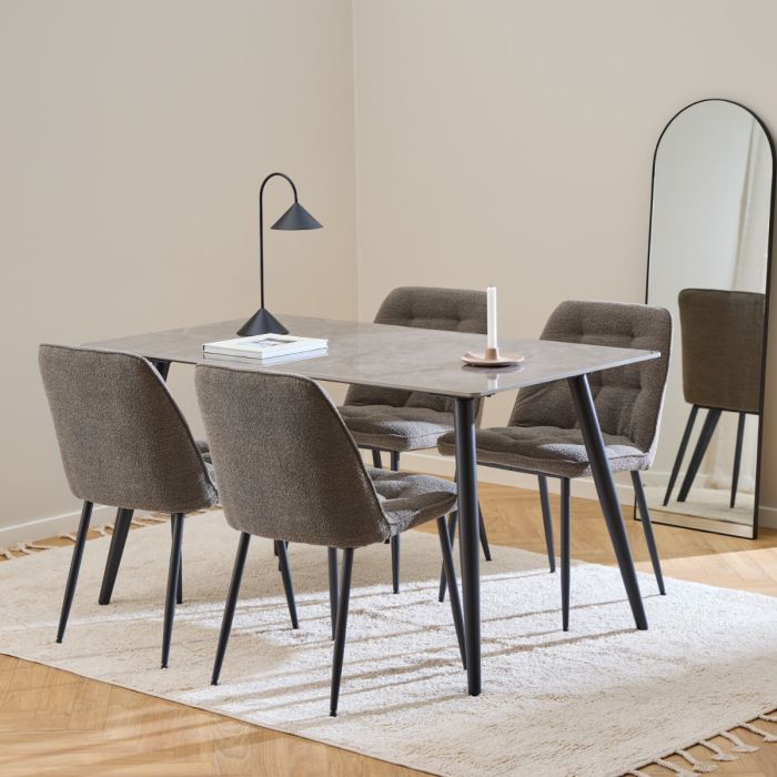 Dining room setup with a table and chairs on a beige rug.