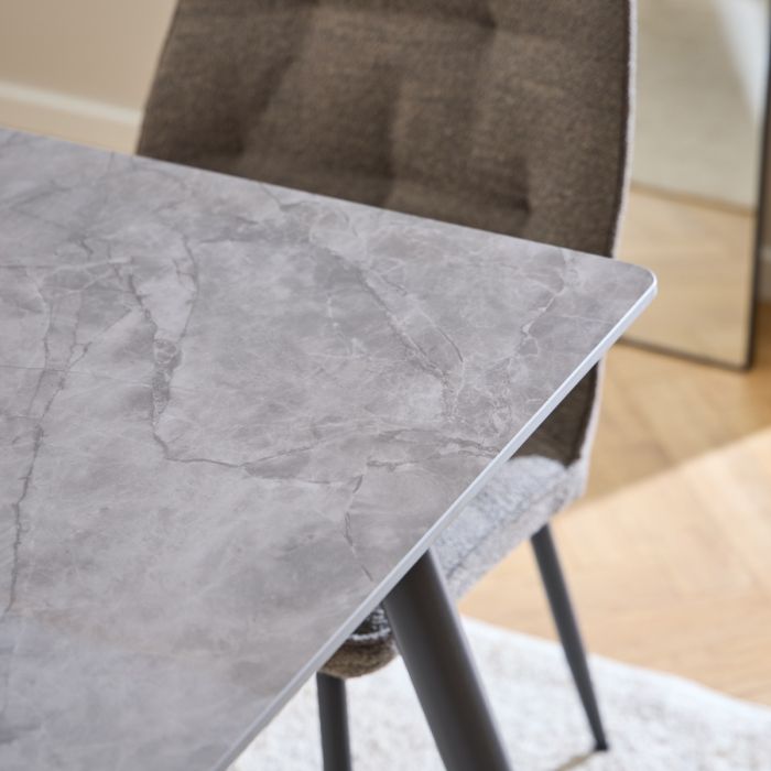 Gray marble-patterned table with a chair in a room setting