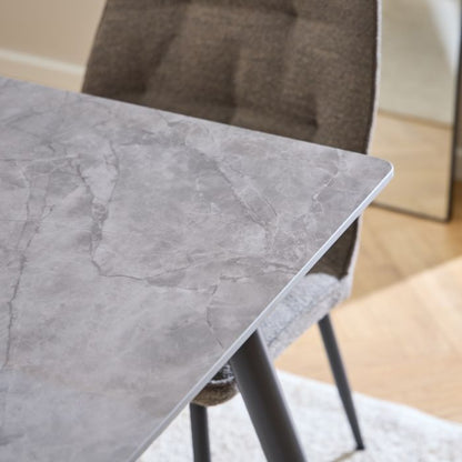 Gray marble-patterned table with a chair in a room setting