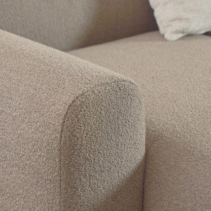 Close-up of a textured beige sofa armrest
