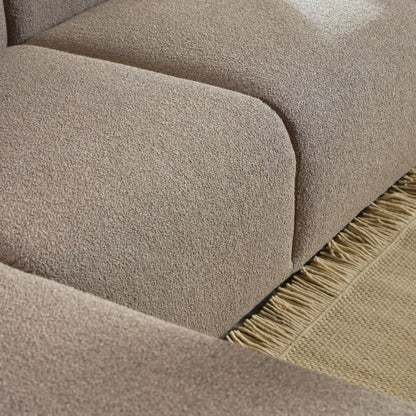 Close-up of a textured beige fabric surface with a fringed edge.