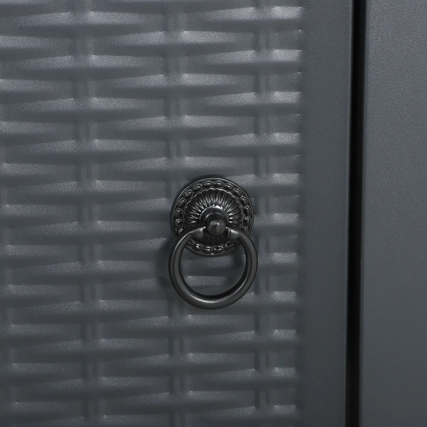 Close-up of a textured gray door with a decorative metal knocker.