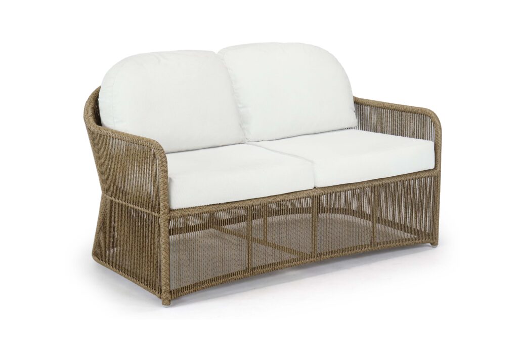 Wicker outdoor sofa with white cushions on a white background