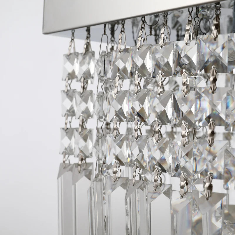 Close-up of a crystal chandelier with clear glass prisms on a white background