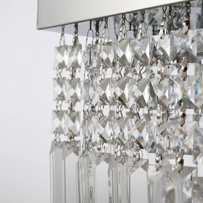 Close-up of a crystal chandelier with clear glass prisms on a white background