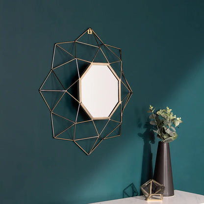 Geometric wall mirror with gold frame on a teal wall