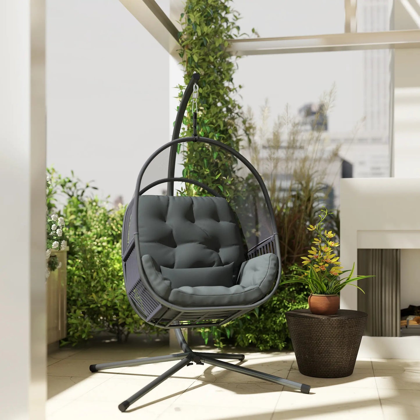 Hanging egg chair with gray cushion in a modern indoor setting with plants.