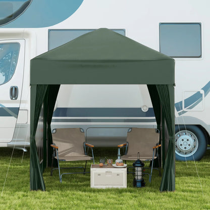 Green pop-up canopy set up outdoors with chairs and a cooler in front of an RV.