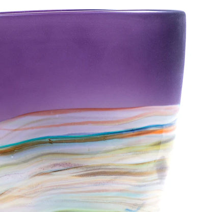 Purple glass bowl with multicolored swirls on a white background