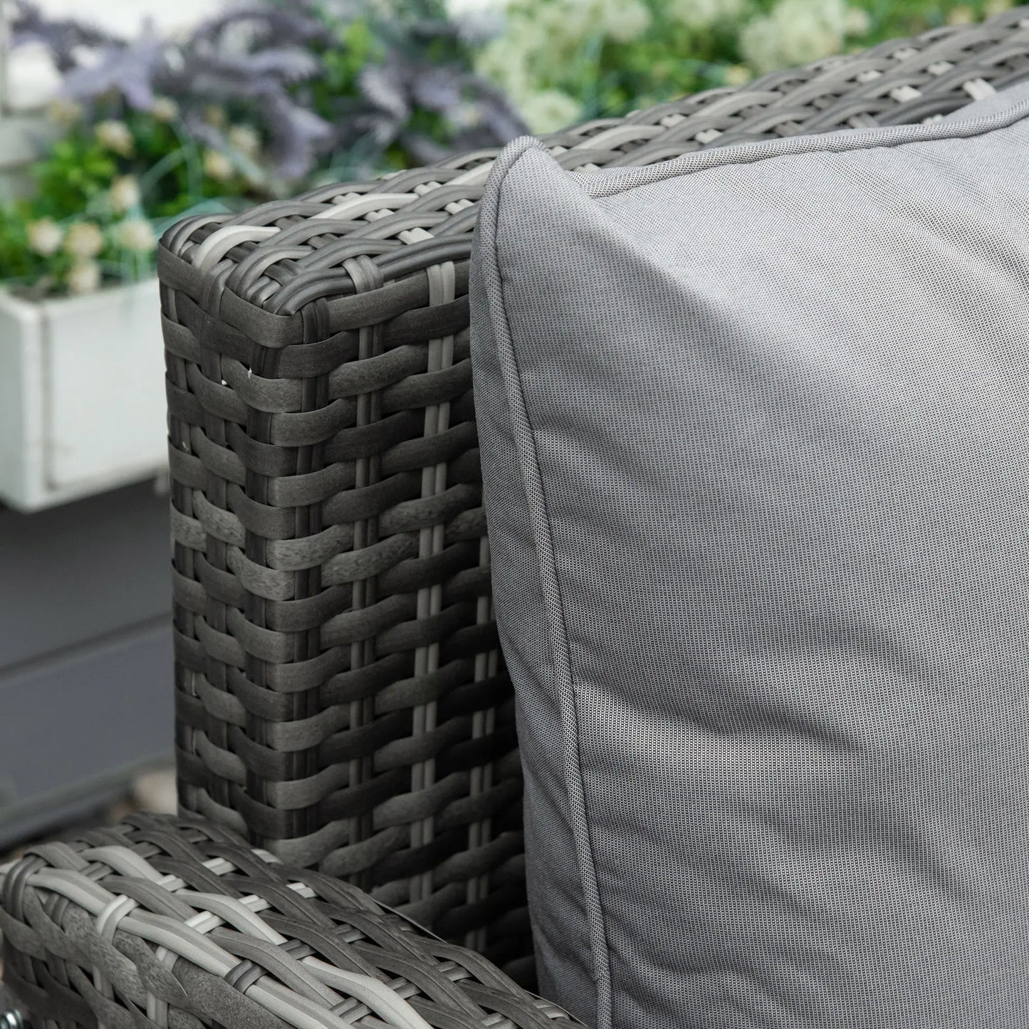Gray wicker chair with a cushion in an outdoor setting