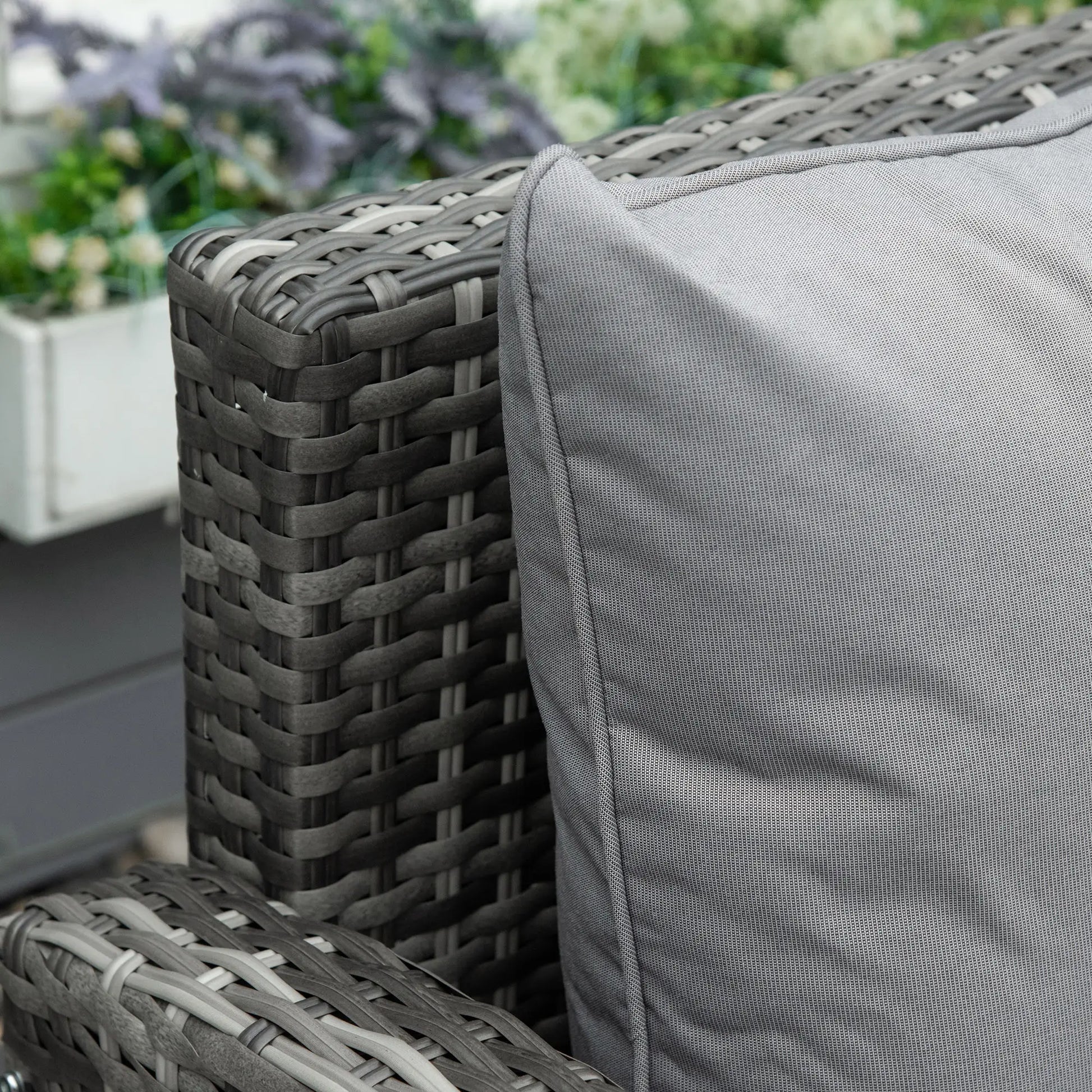 Gray wicker chair with a cushion in an outdoor setting