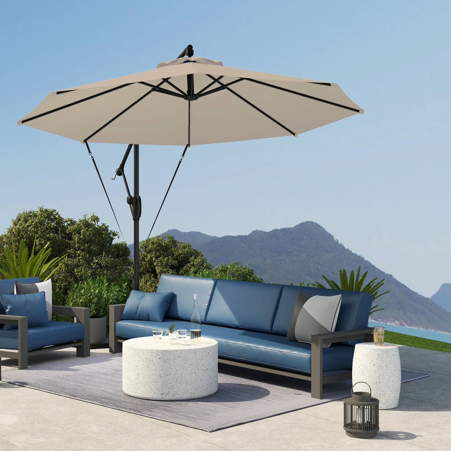 Outdoor patio set with blue sofa, chairs, and umbrella against a mountainous background.