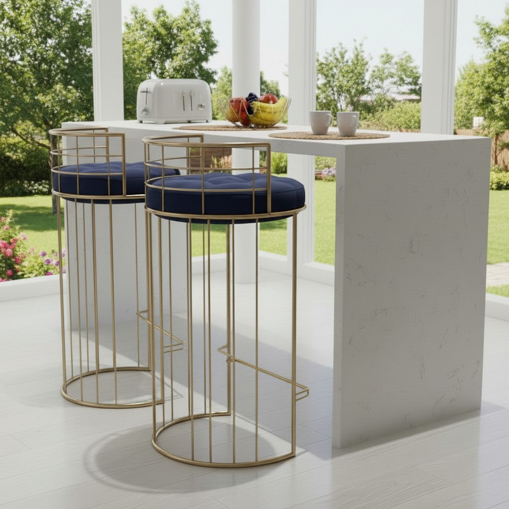 Two gold stools with navy cushions in front of a white outdoor bar.