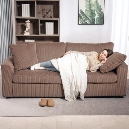 Woman lying on a brown sofa in a living room with a bookshelf and plant in the background.