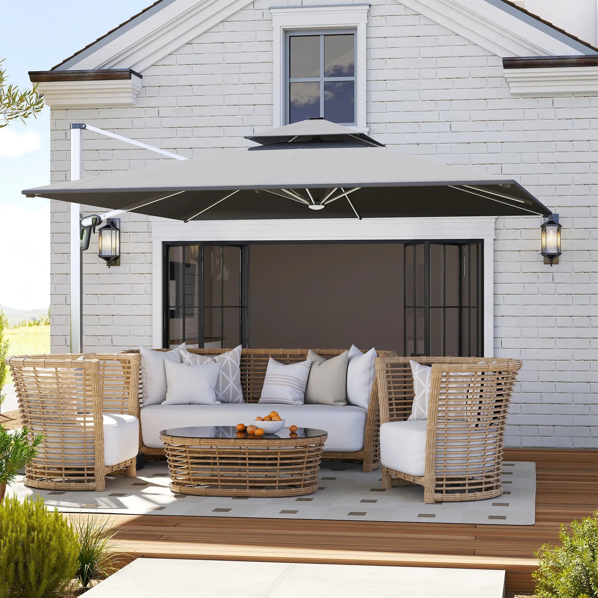 Outdoor patio set with wicker furniture and cushions on a deck in front of a house.