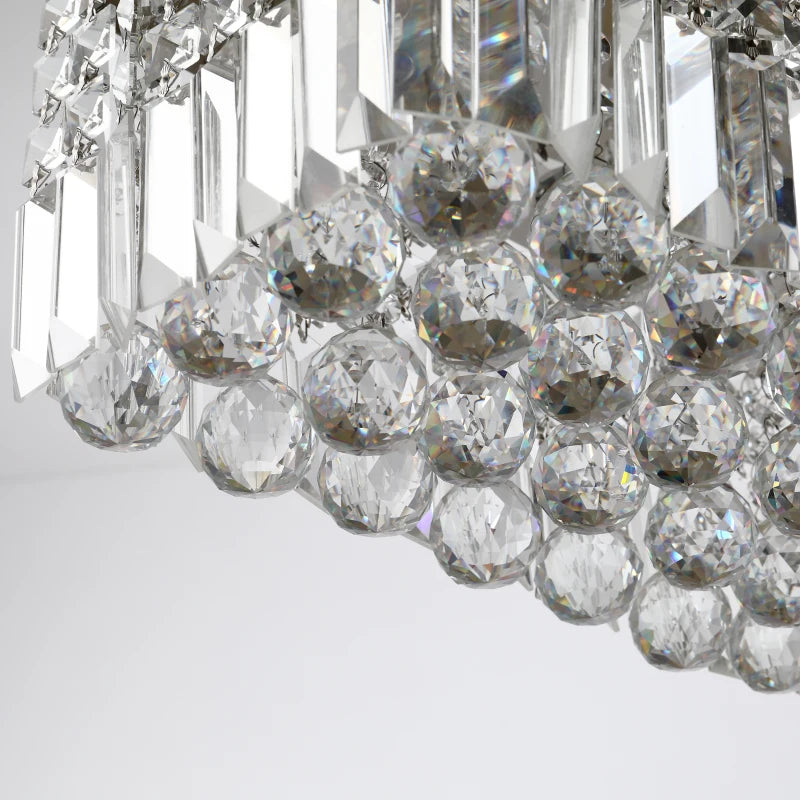 Close-up of a crystal chandelier with clear and silver elements on a light gray background