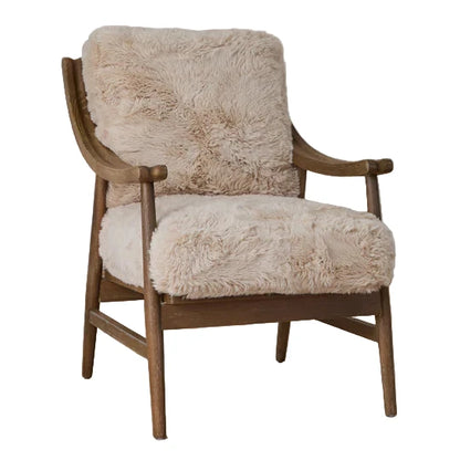 Chair with beige fur cushion on a wooden floor against a white paneled wall.