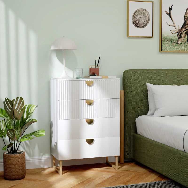 White dresser with gold accents next to a green bed in a room with light green walls.