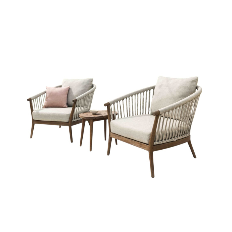 Two wooden chairs with white cushions and a small table on a white background