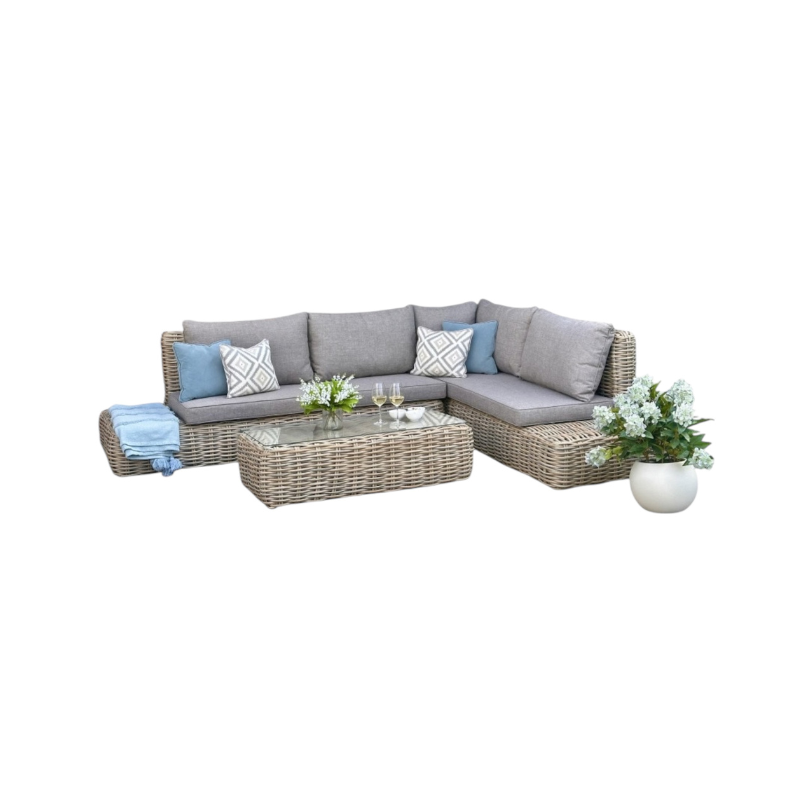 Outdoor furniture set with a sectional sofa, coffee table, and decorative items on a white background