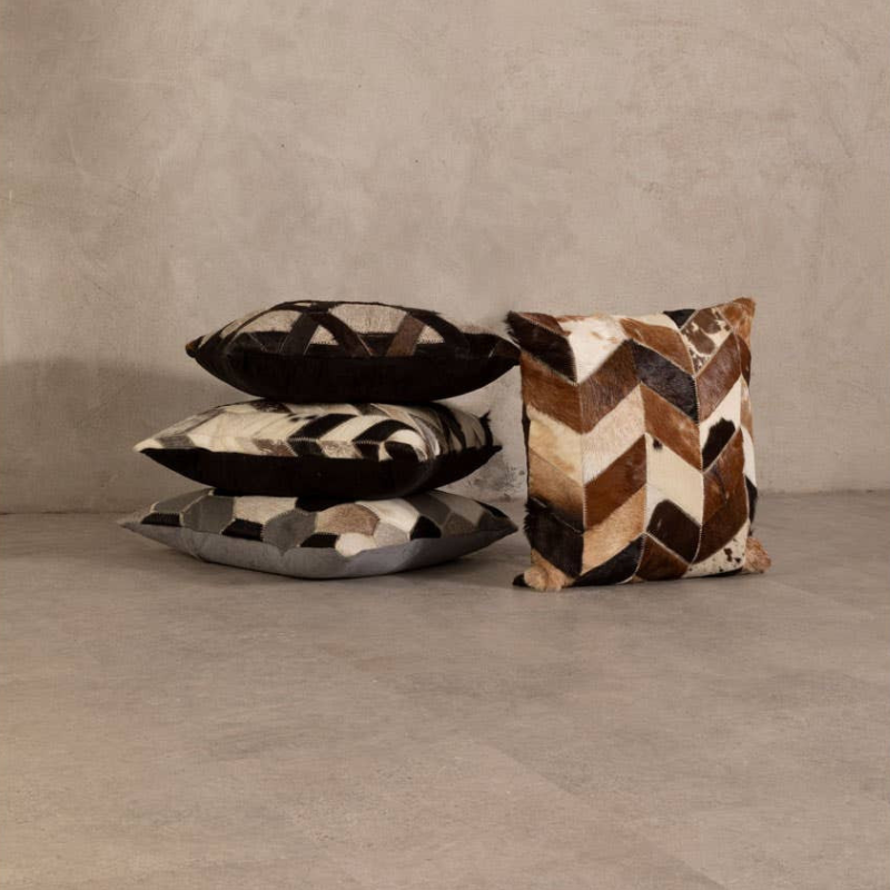 Three patterned pillows on a neutral background
