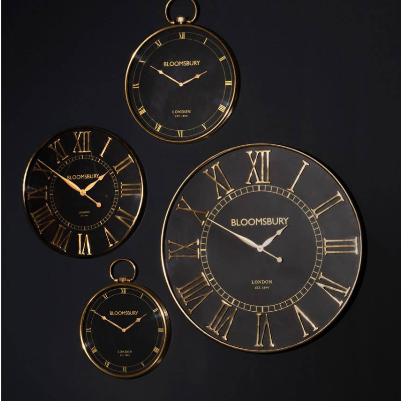Set of Bloomsbury wall clocks with gold Roman numeral design on a black background