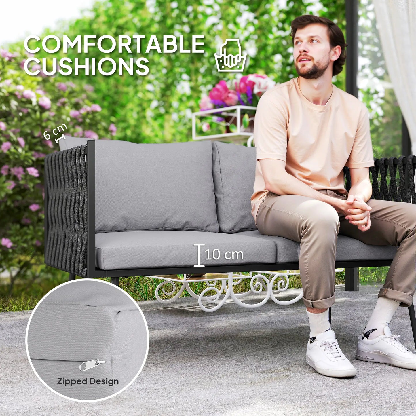 Man sitting on a gray outdoor sofa with comfortable cushions, surrounded by greenery.
