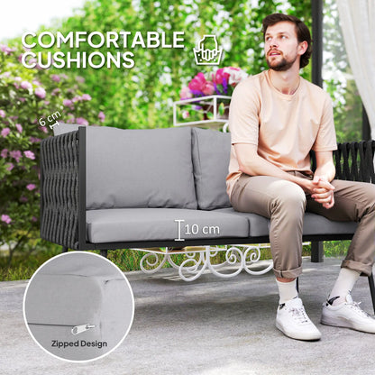 Man sitting on a gray outdoor sofa with comfortable cushions, surrounded by greenery.
