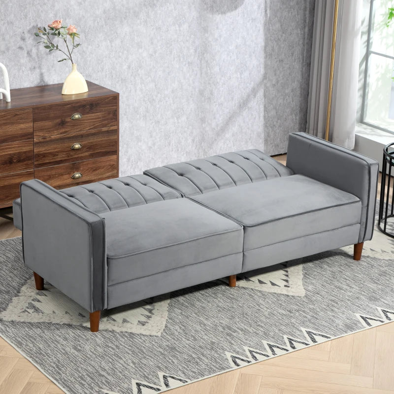 Gray sofa bed in a living room setting with a wooden cabinet and rug.