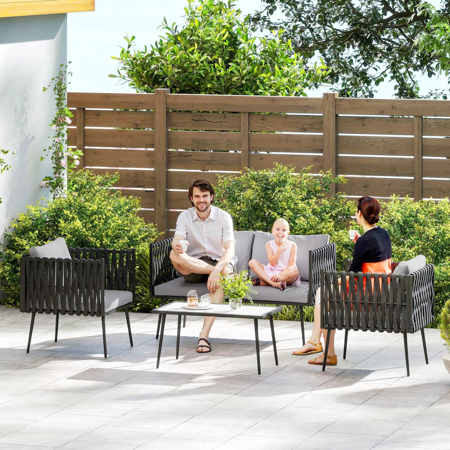 Family sitting on outdoor furniture set in a garden