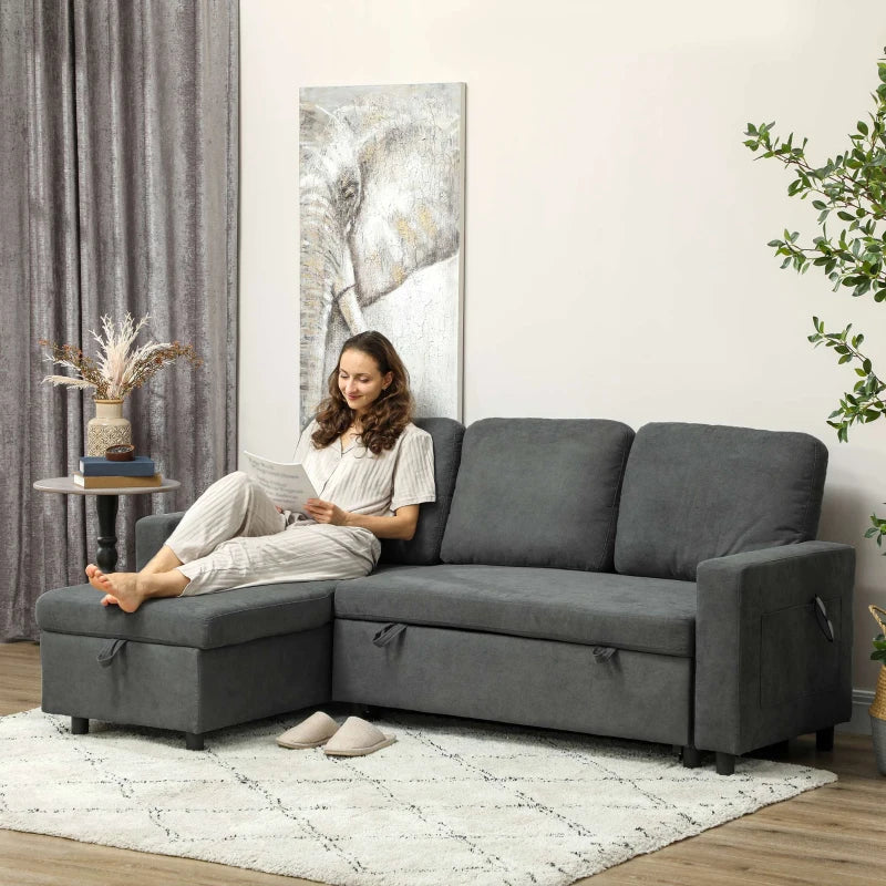 Woman sitting on a gray sectional sofa in a living room with a large abstract painting on the wall.