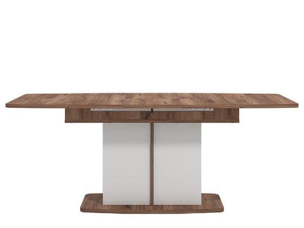 Wooden dining table with a white base on a white background