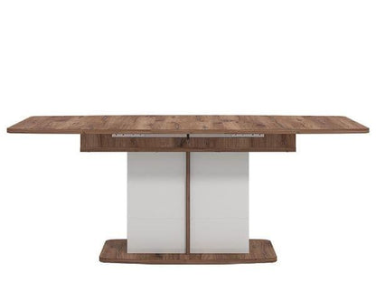 Wooden dining table with a white base on a white background