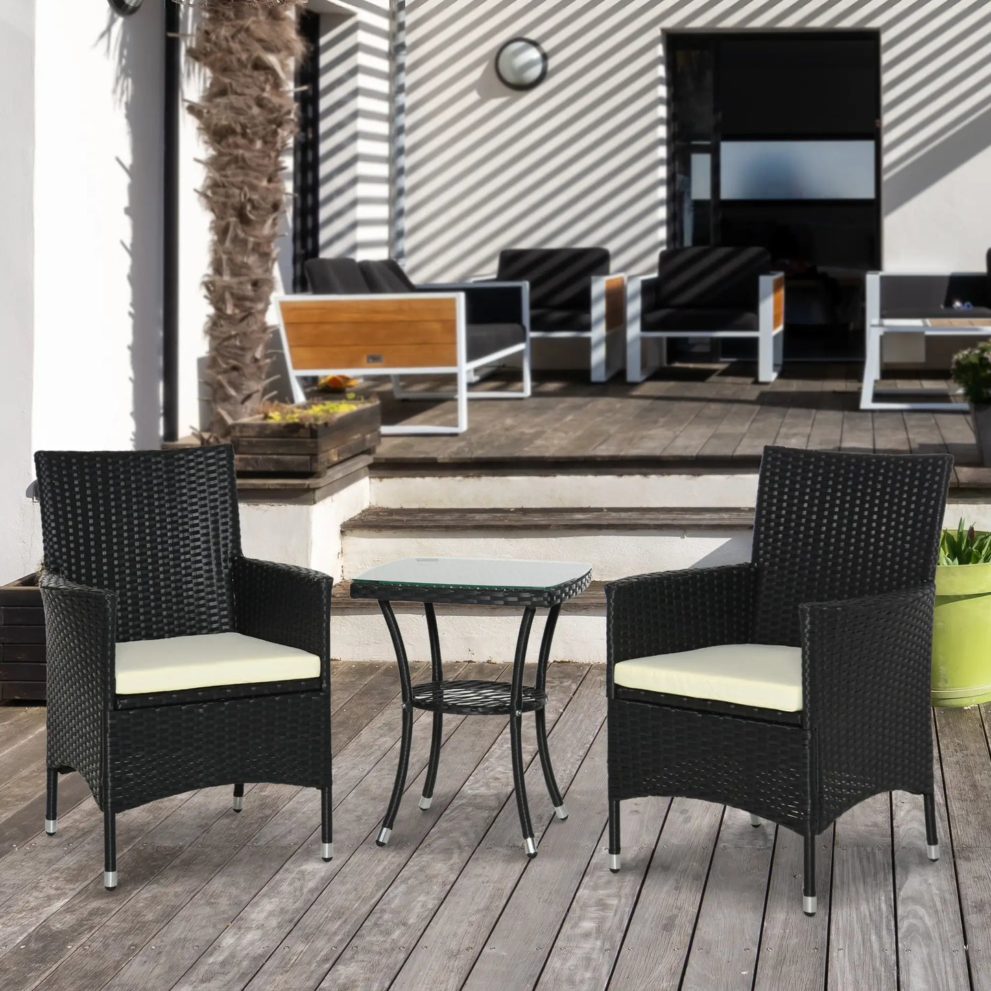 Outdoor patio set with two chairs and a table on a wooden deck.