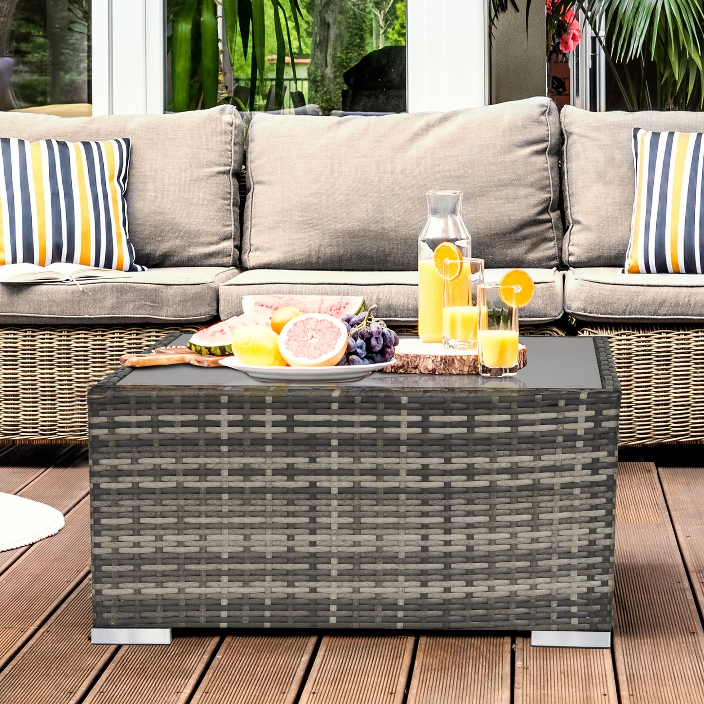 Outdoor patio set with a coffee table, cushions, and fruit on a wooden deck.