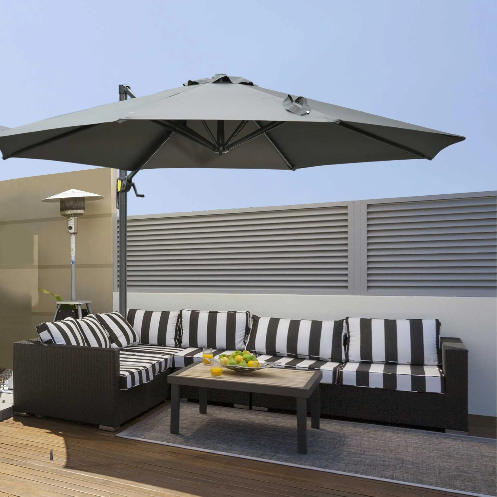 Outdoor patio set with striped cushions, umbrella, and small table on a deck.