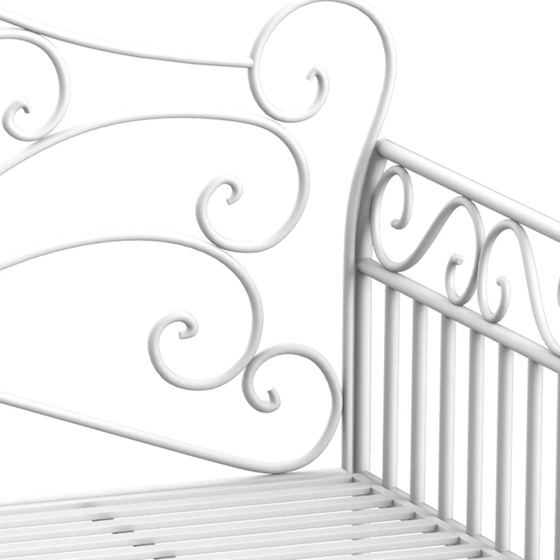 Close-up of a white metal crib with decorative scrollwork on a white background