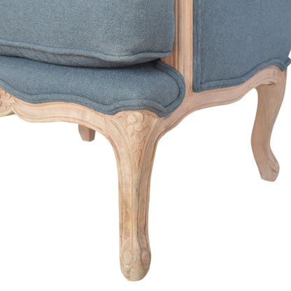 Close-up of a chair with blue fabric and wooden legs on a white background
